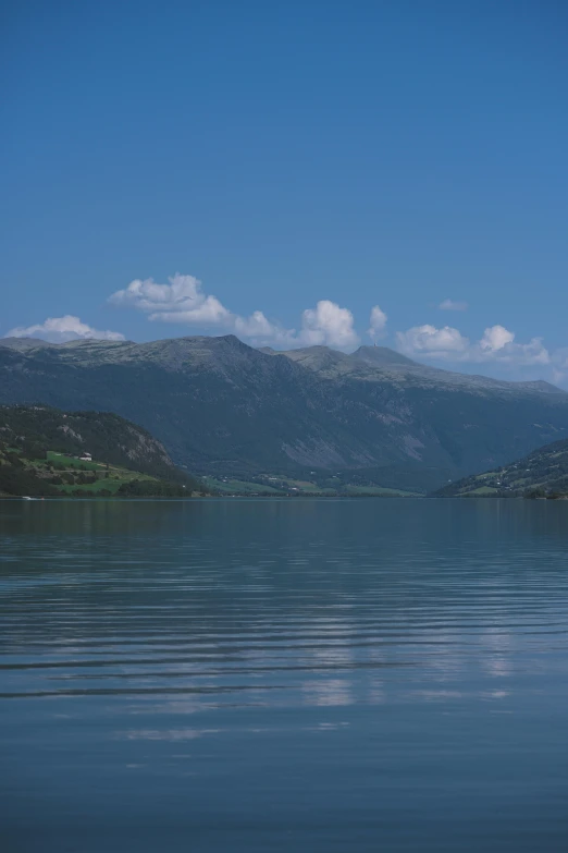 a boat floating in a large lake on a nice day