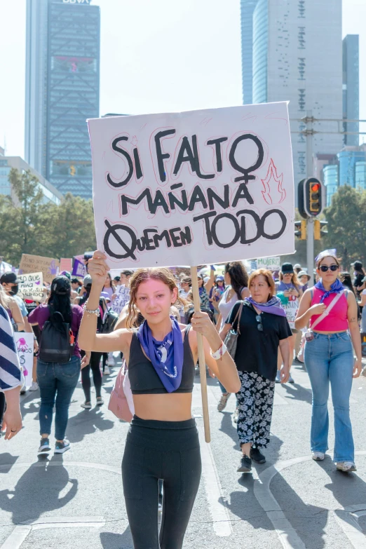 women in a protest in the street hold signs