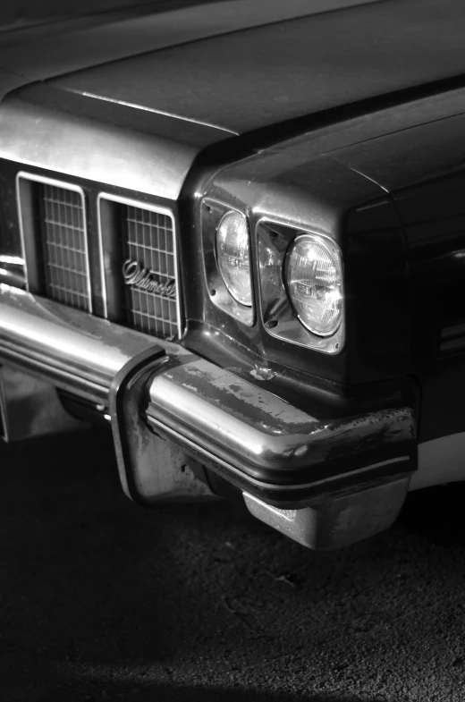 the front end of a classic car in black and white