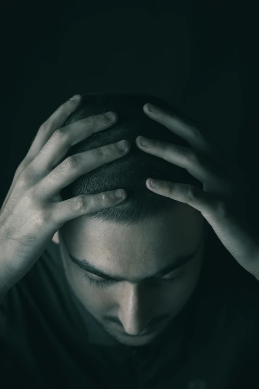 a man holding his hands up to his head