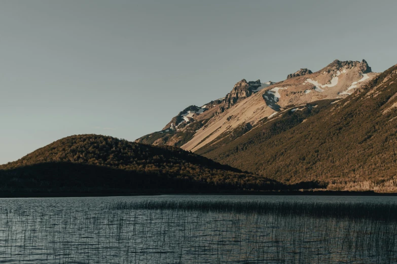 mountains near a body of water and clouds