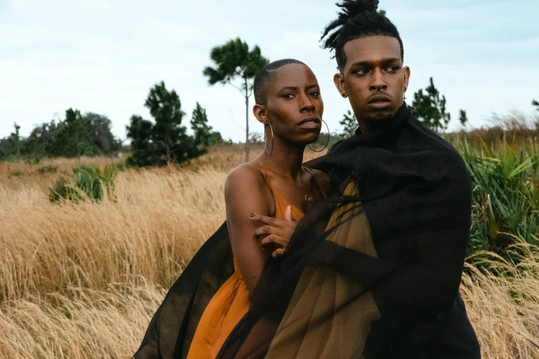 a couple of people standing next to each other on a field