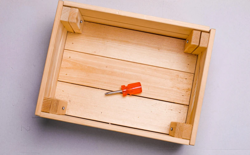 a pair of scissors are sticking out of an empty wood tray