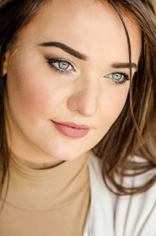 woman with blue eyes and makeup, in a neutral fashion