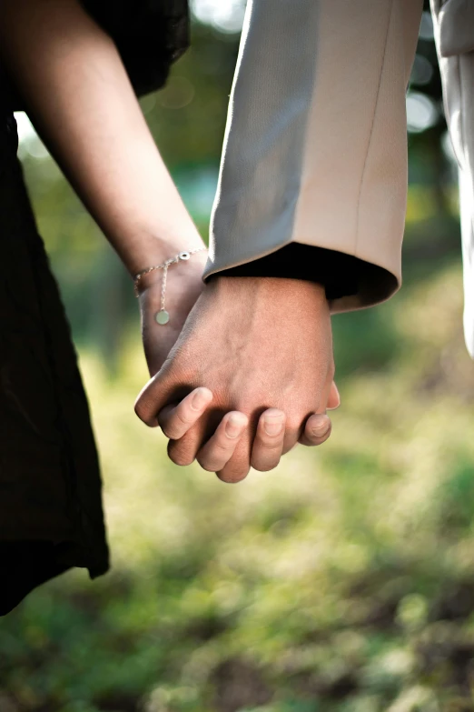 a man and woman hold hands outside