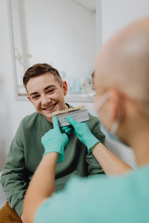 a person putting on gloves while another person brushes their teeth