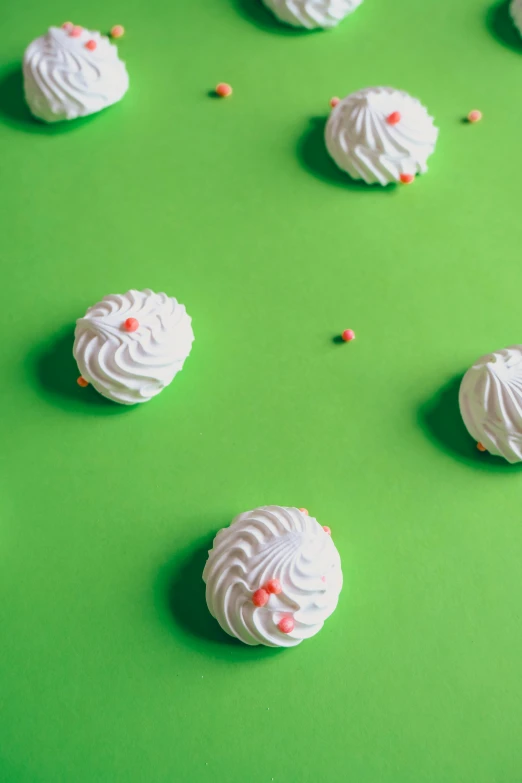 white chocolate balls and sprinkles on a green surface