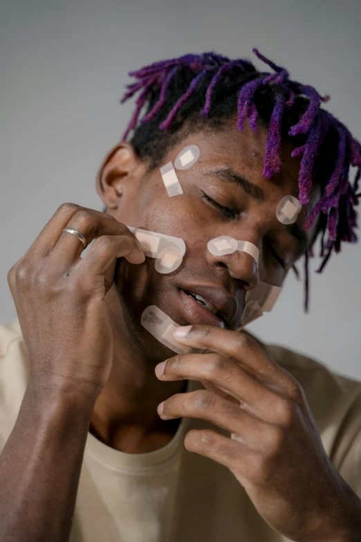 a man with dread locks on his head holding his hands together