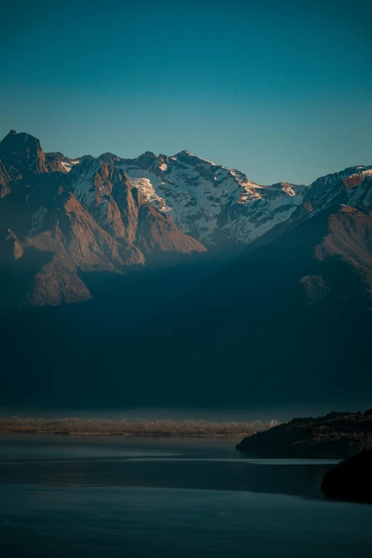 the mountain range sits over the body of water