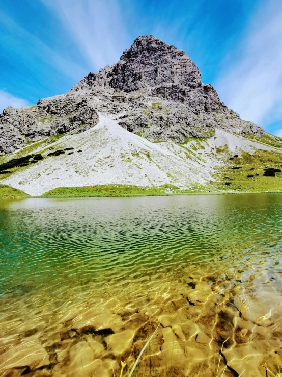 some green water and a big rock mountain