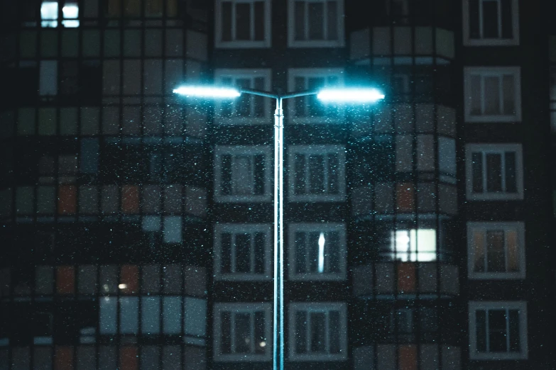 street light lit up at night with rainy windows