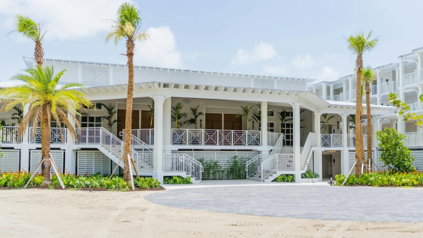 an old white house that is on the beach