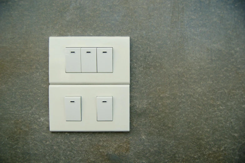 two white electrical outlets on a wall near one another