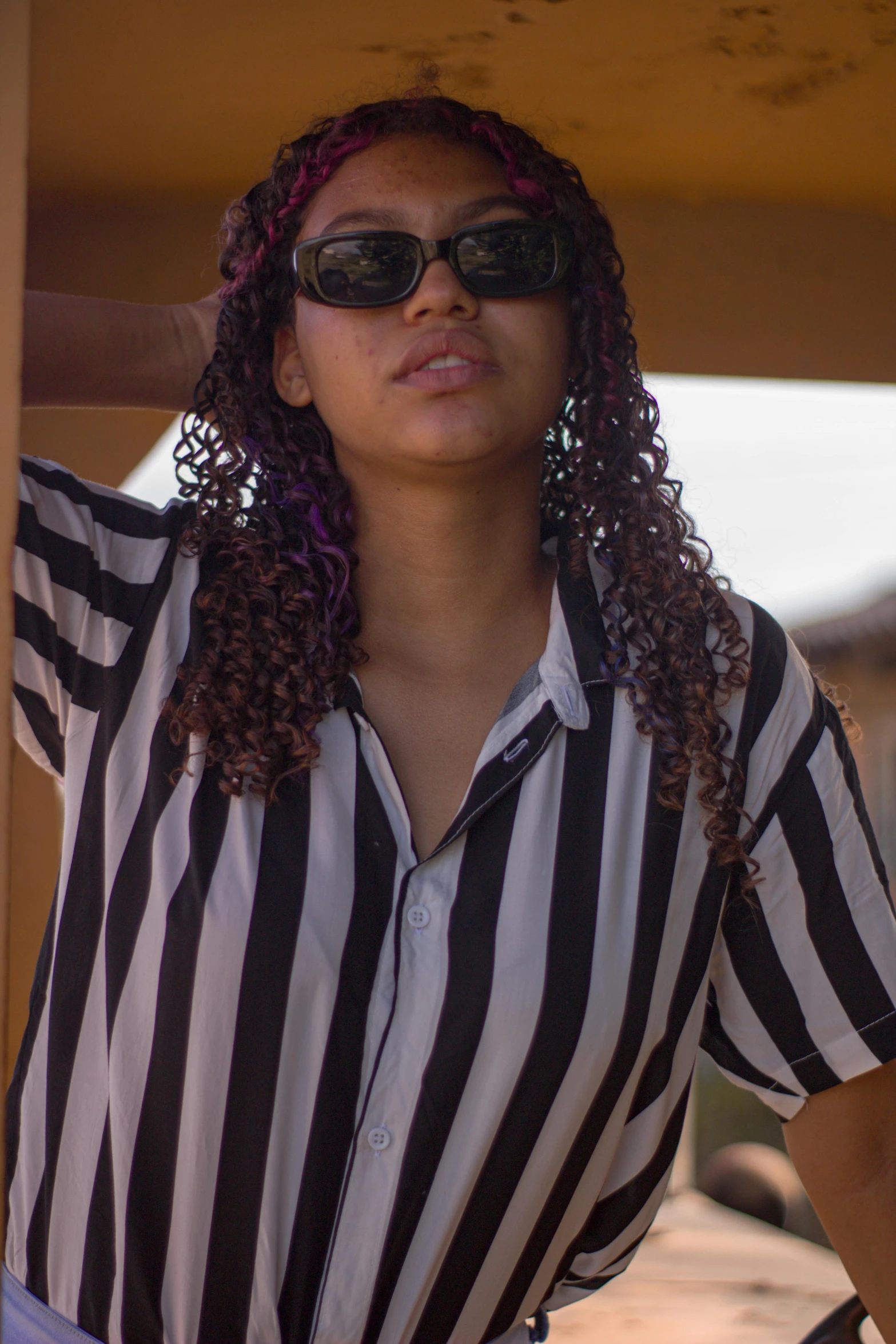 an african american woman wearing sun glasses and striped shirt