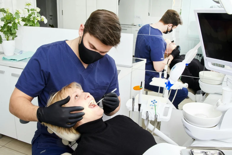 there is a male and female getting their teeth checked