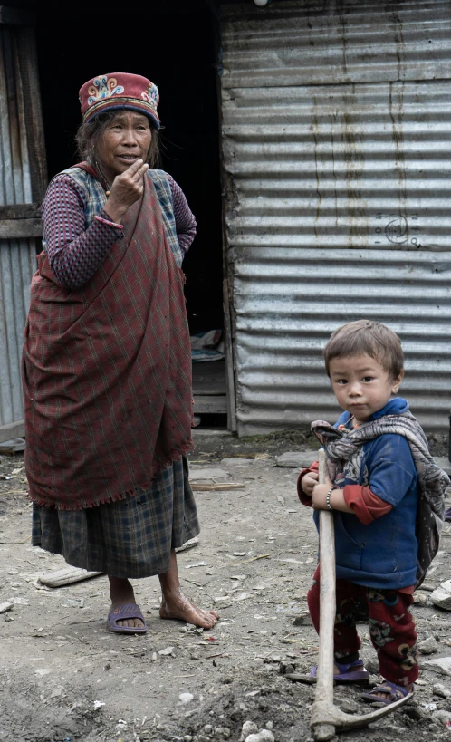 an older lady is holding a baseball bat and a toddler