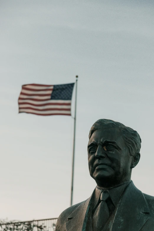 the american flag is in the air over the statue