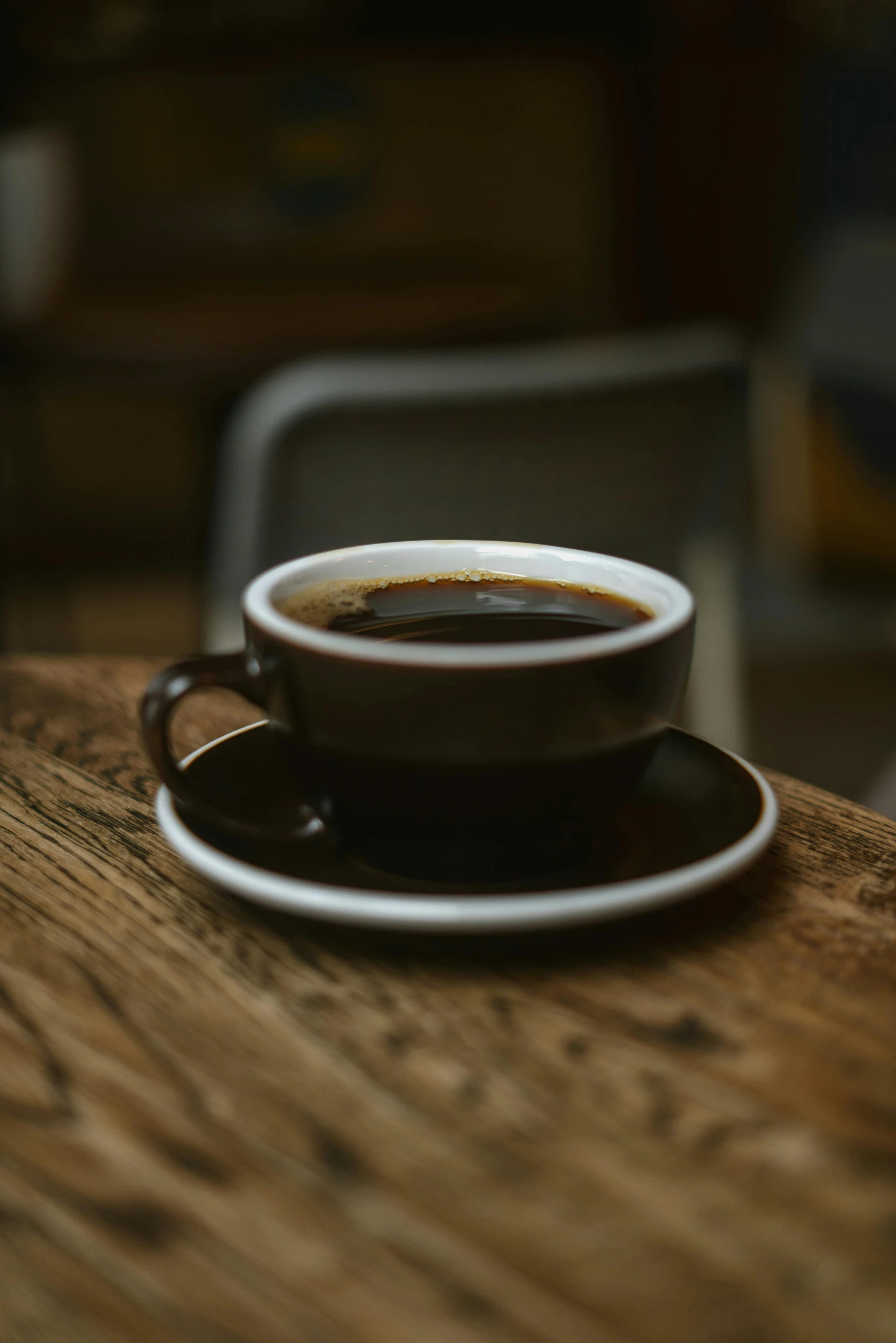 coffee cup on table with chair in background