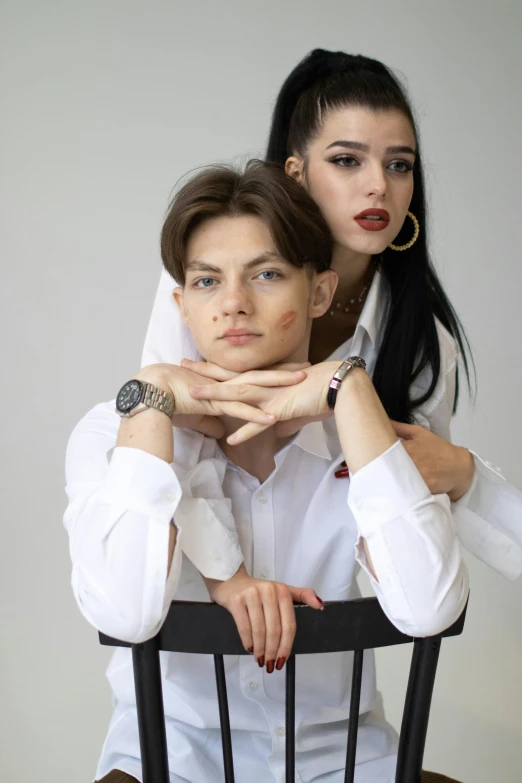 a woman standing behind a man sitting at a table