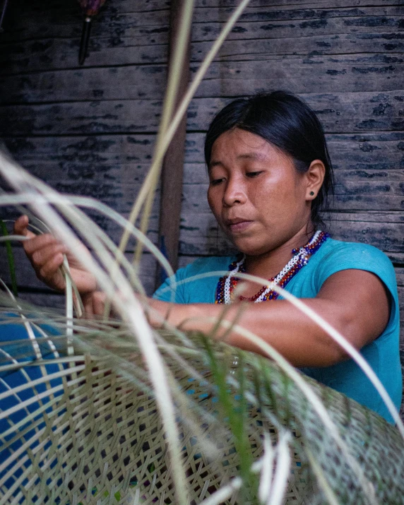 a woman that is sitting in front of grass