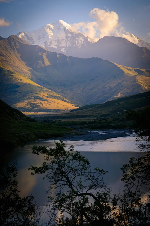 the mountains are covered in snow near a body of water