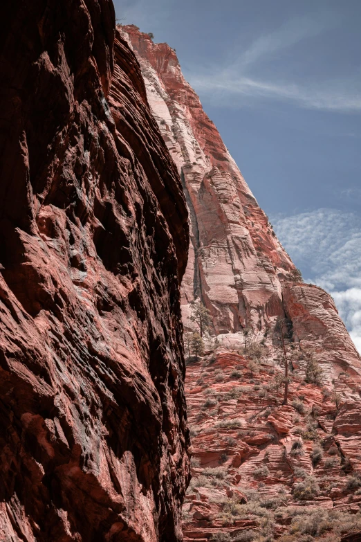 a large rock face next to a small building