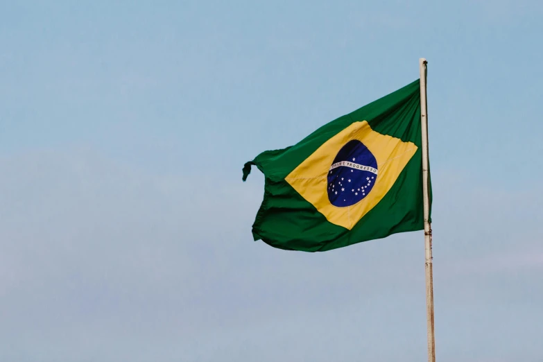 a flag flying in the wind against a blue sky