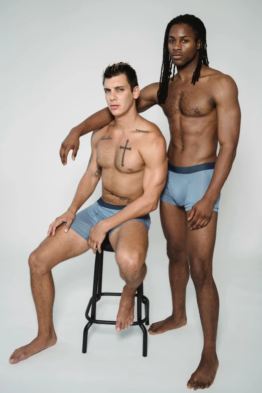 the two men are posing together in their underwear