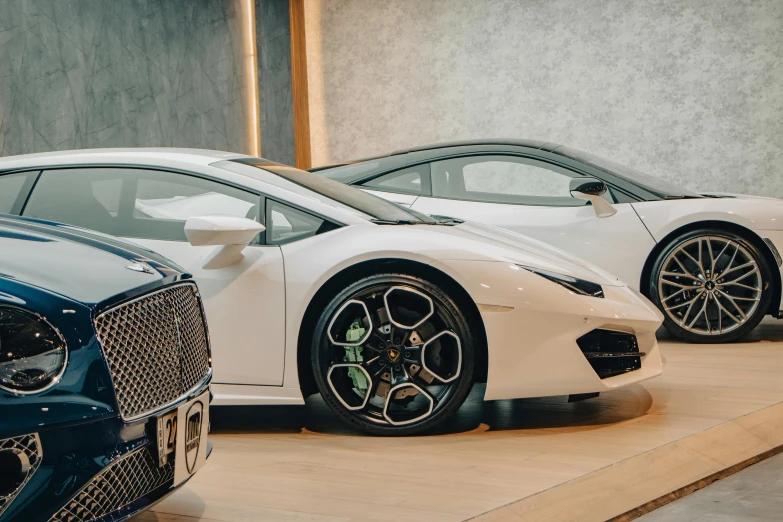 two white sports cars in showroom next to each other