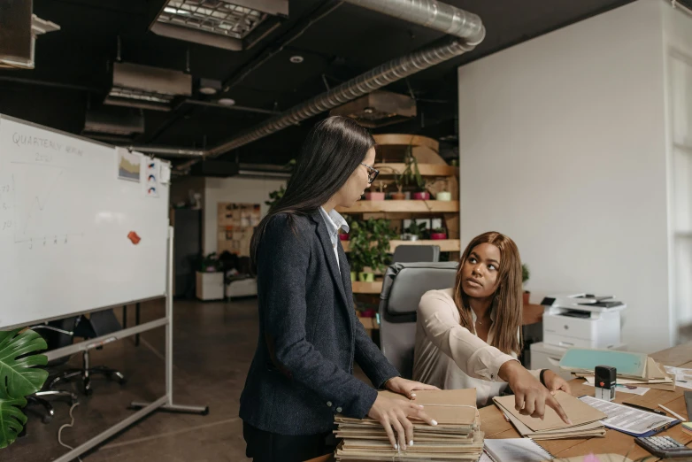 two business women standing in an office setting