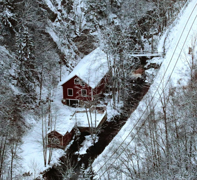 red cottage surrounded by trees and snow