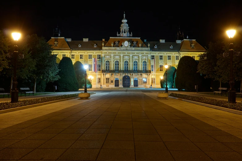 large stone walkway with a building and lights on