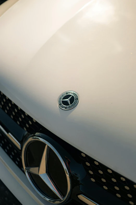 a mercedes car badge sitting on the front end