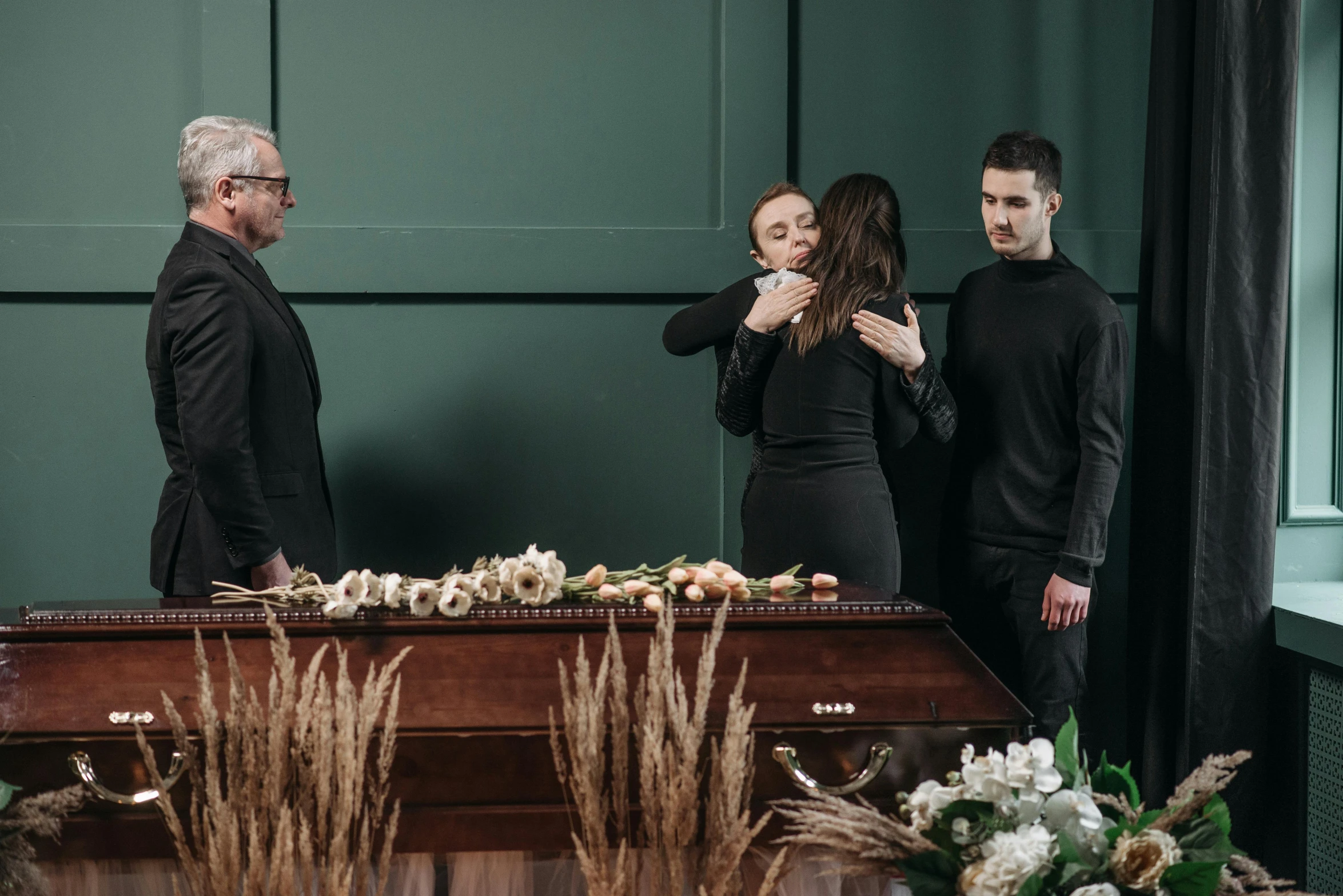 three people standing around a table and a lady