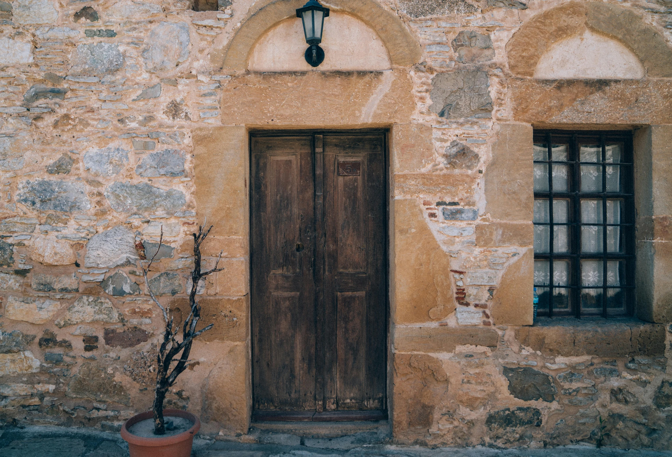 an entrance to a stone building with a wooden door and window