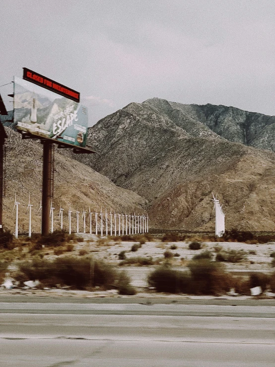 the giant stop sign is located between the highway and mountains