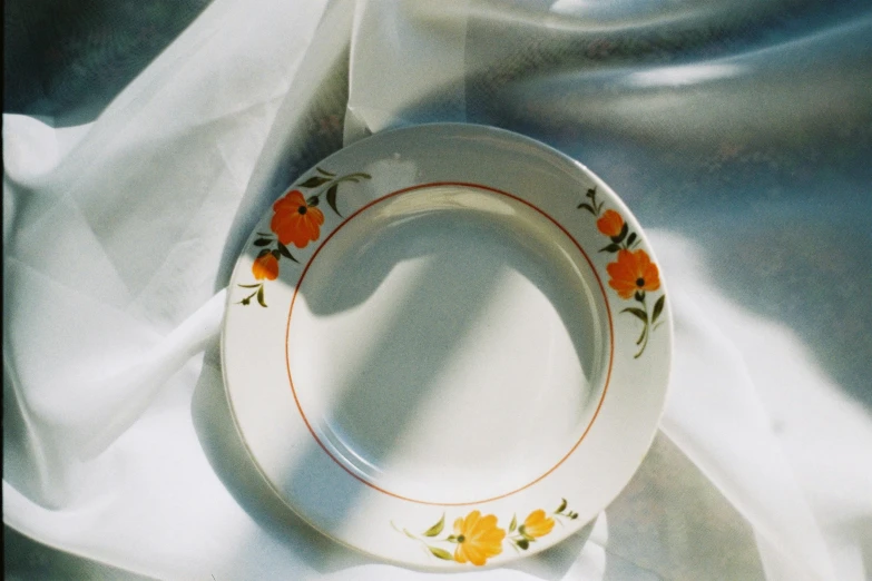 a white plate with an orange border and small flowers