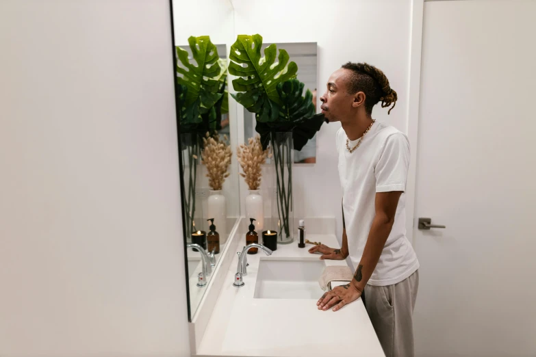 a man is staring in the mirror while standing in front of his sink