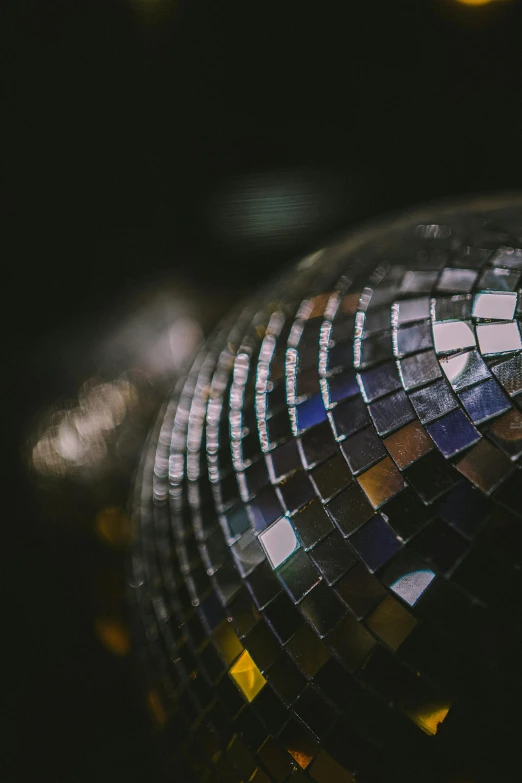 a closeup of a disco ball made up of many different colored mosaic tiles