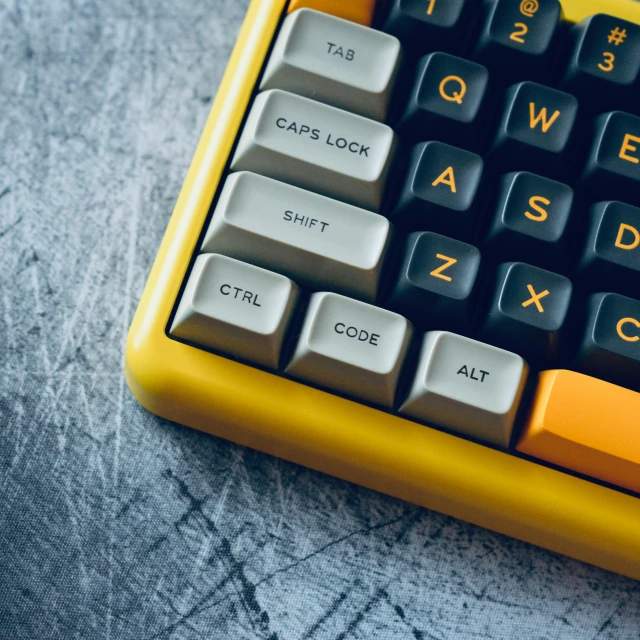 an old yellow computer keyboard sitting on top of a table