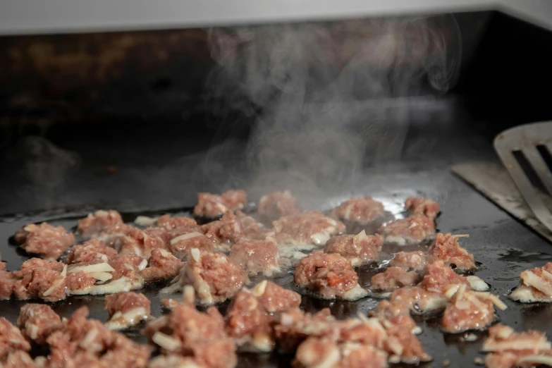 a bunch of meatballs cooking on a stove