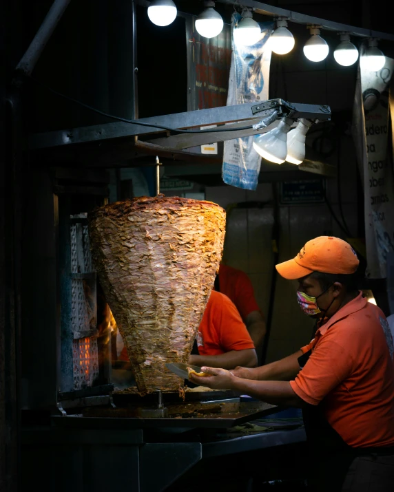 two men work at an oven in a large industrial facility