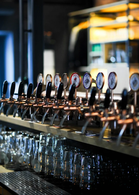 a bar top filled with glasses of different colors and sizes