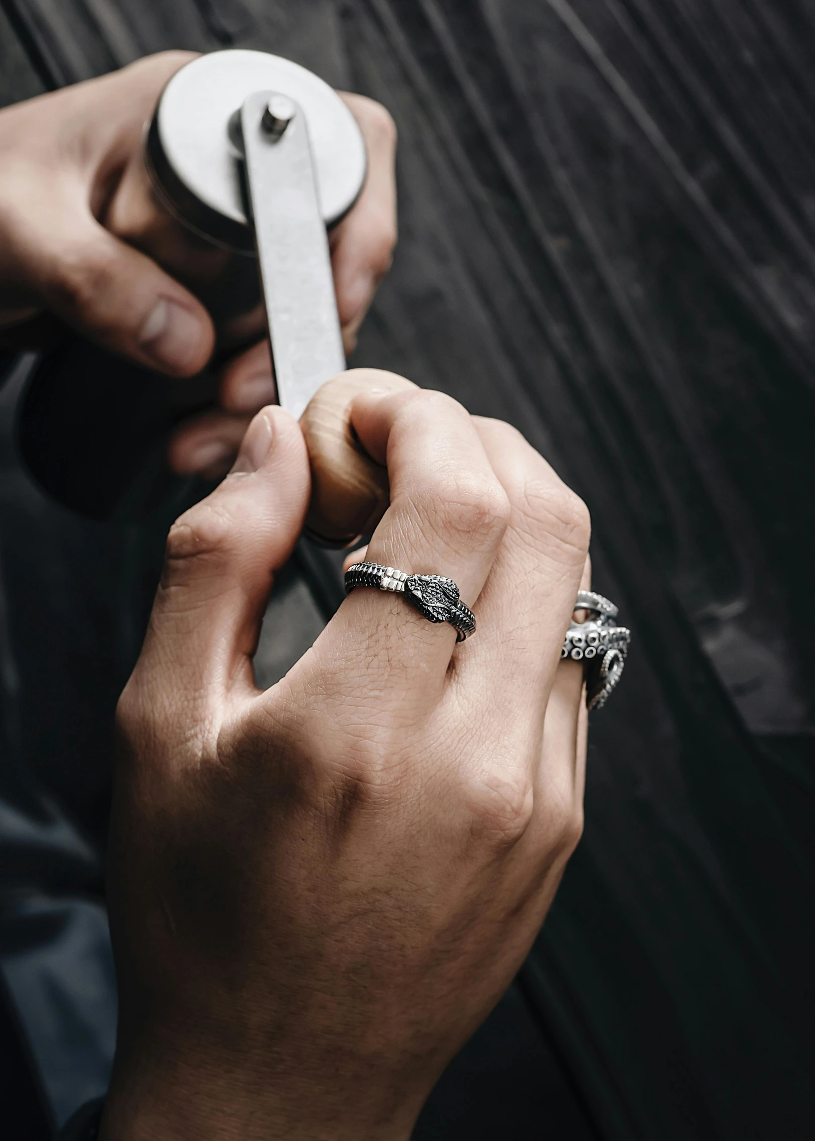 there is a male holding a silver ring on his hand