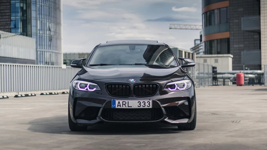 a grey bmw vehicle in the middle of a parking lot