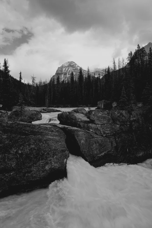 black and white image of flowing water in mountains