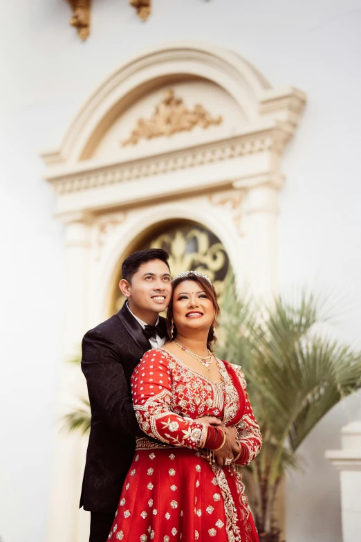 a young couple dressed in formal attire posing for a po