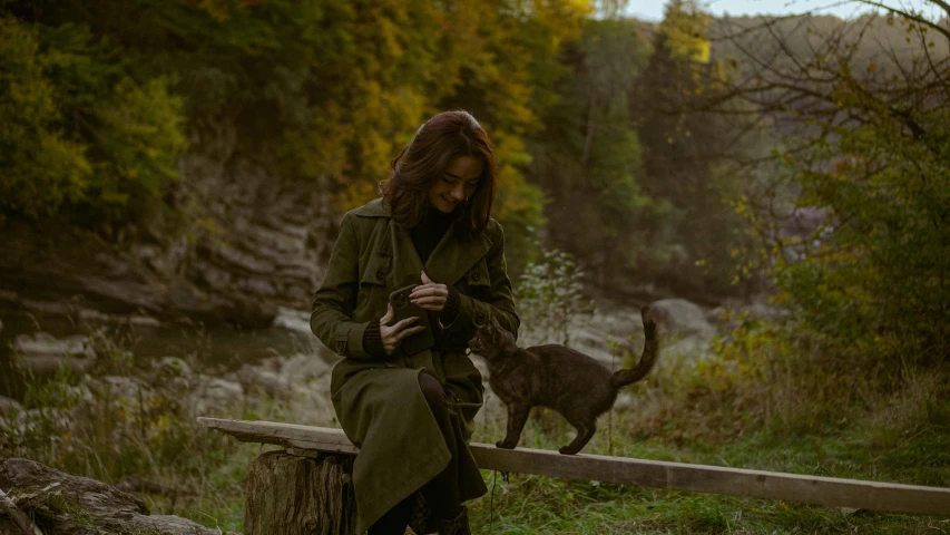 a person is looking at her phone while a dog is outside