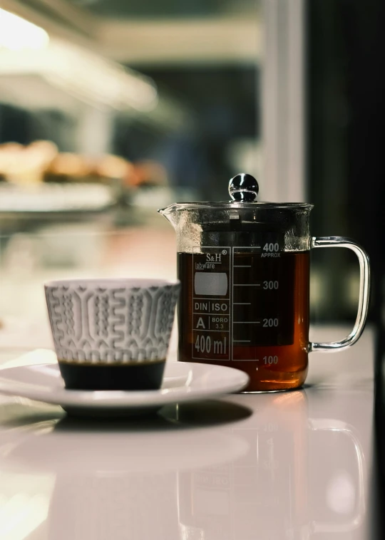 an iced drink in a glass container next to a measuring cup