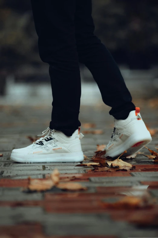 a person walking along an urban street in white shoes